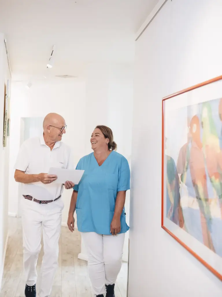 Dr. Birch und eine Mitarbeiterin auf dem Praxisflur