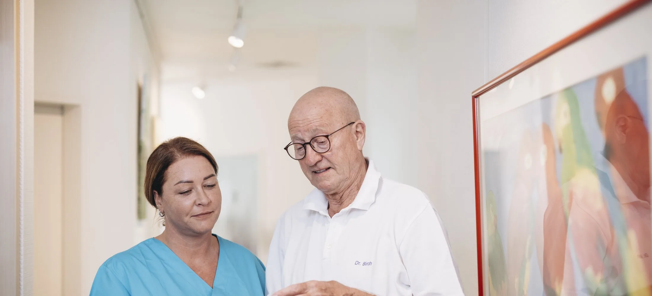 Dr. Birch und eine Mitarbeiterin sehen gemeinsam Unterlagen durch